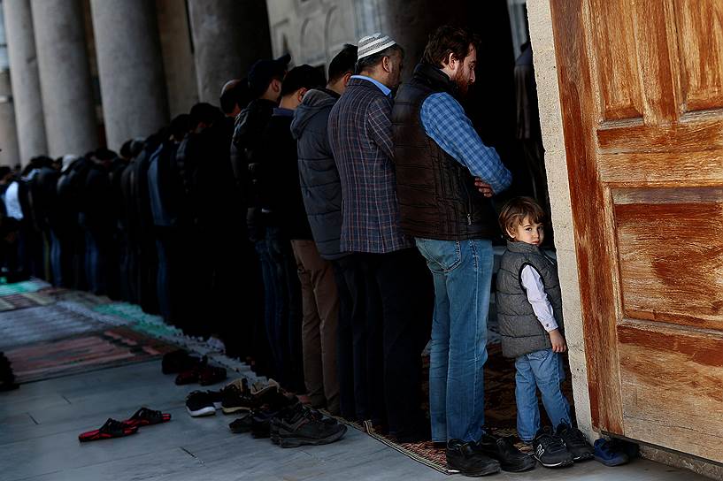 Стамбул, Турция. Мужчины во время молитвы в мечети Фатих