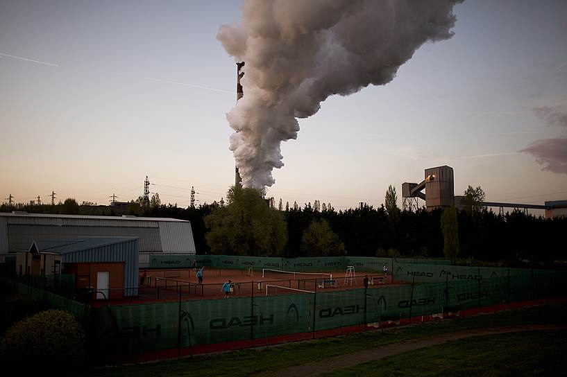 Теннисный корт в Эанже на фоне дымящей трубы одного из заводов
