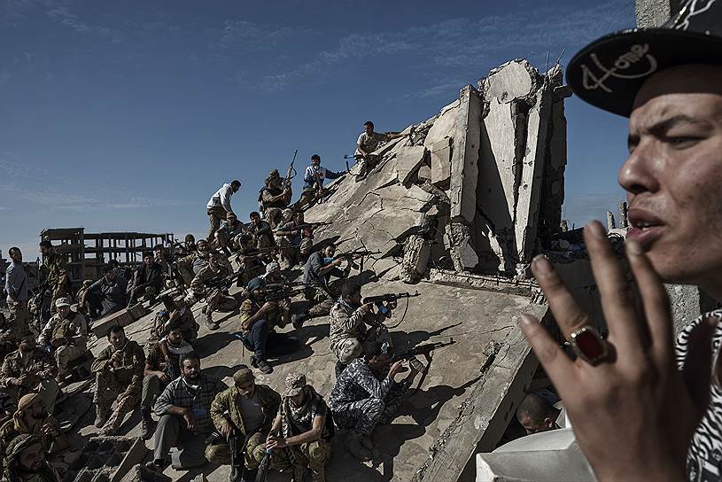 Ливийские военные отдыхают на развалинах города Сирт во время боев с террористами «Исламского государства» (запрещено в РФ)