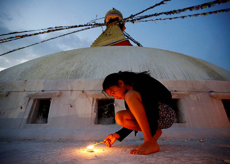 Катманду, Непал. Девочка зажигает свечу в память о жертвах землетрясения, которое произошло в стране в 2015 году