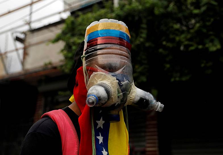 Каракас, Венесуэла. Участник уличных протестов в самодельном противогазе