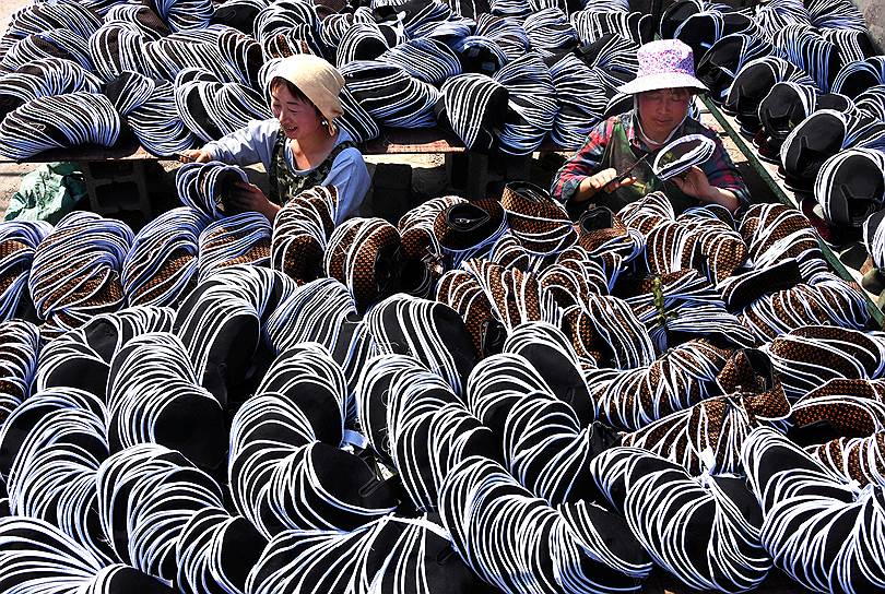 Июань, Китай. Сотрудники фабрики по производству обуви за работой