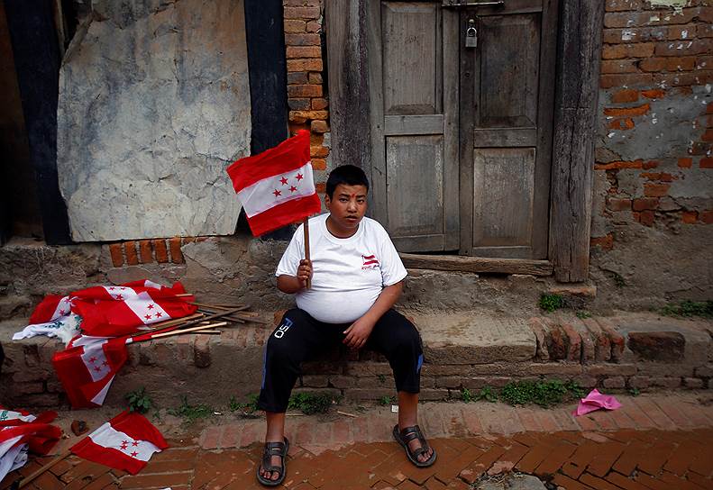 Бхактапур, Непал. Мужчина с флагом одной из партий перед выборами, запланированными на 14 мая