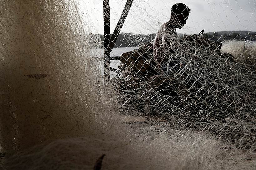 Ояпоки, Бразилия. Местный житель работает с рыболовной сетью