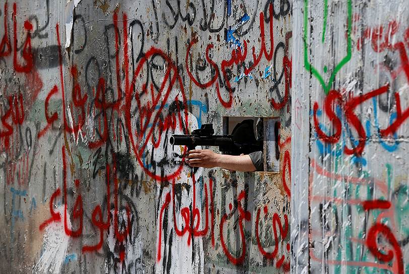 Вифлеем, Палестина. Полицейский целится в участников акции в поддержку заключенных-палестинцев, которые объявили голодовку в израильских тюрьмах