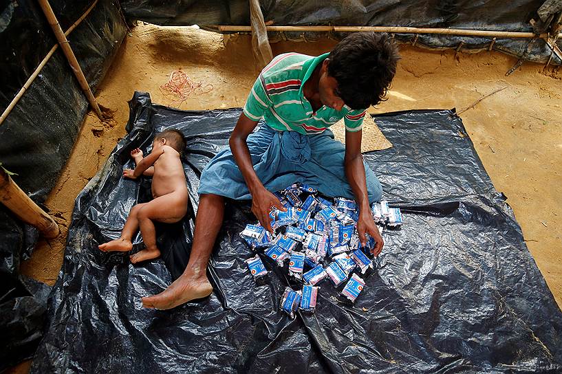 Кокс-Базар, Бангладеш. Мужчина рассматривает гуманитарную помощь в лагере для беженцев 