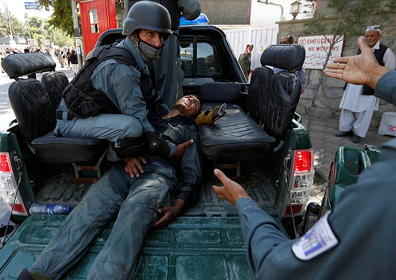 Кабул, Афганистан. Полицейские везут в госпиталь своего сослуживца, раненного во время столкновений с демонстрантами 