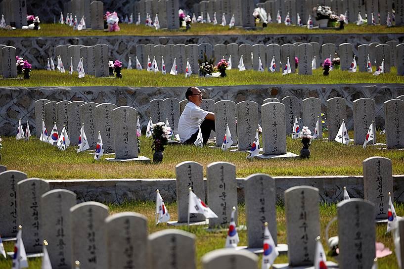 Сеул, Южная Корея. Мужчина у могилы родственника накануне Дня памяти, когда жители страны поминают погибших во время Корейской войны 1950—1953 годов 