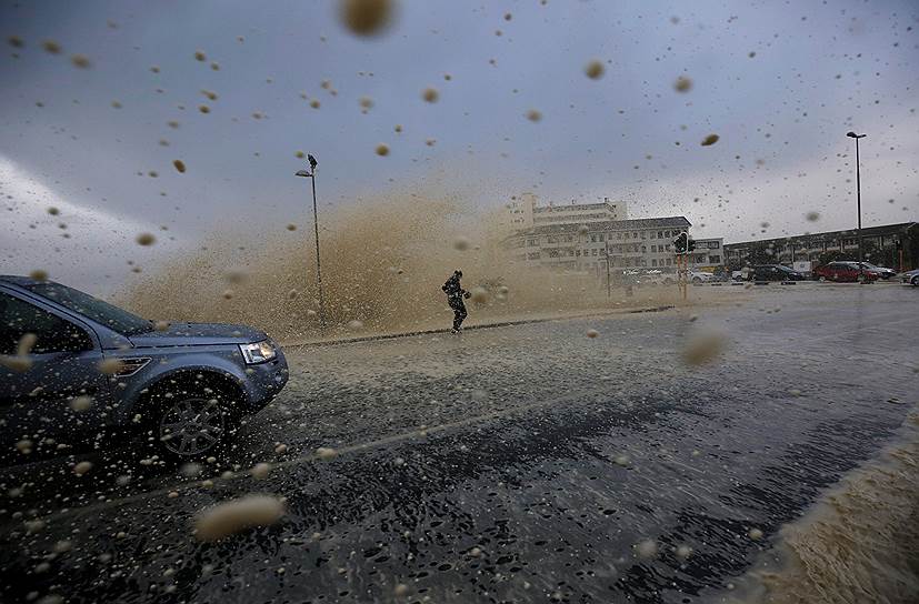 Кейптаун, ЮАР. Мужчина пытается убежать от штормовой волны 