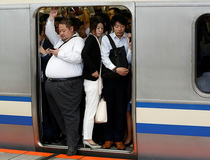 Кавасаки, Япония. Пассажиры пытаются зайти в переполненный вагон на станции