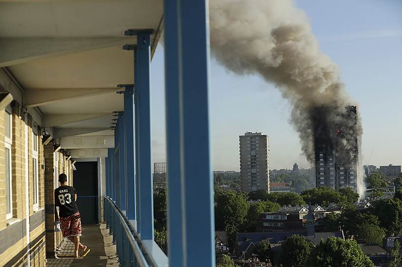 Лондон, Великобритания. Местный житель смотрит на горящее 27-этажное здание. Жертвами пожара в жилом здании Grenfell Tower стали 12 человек