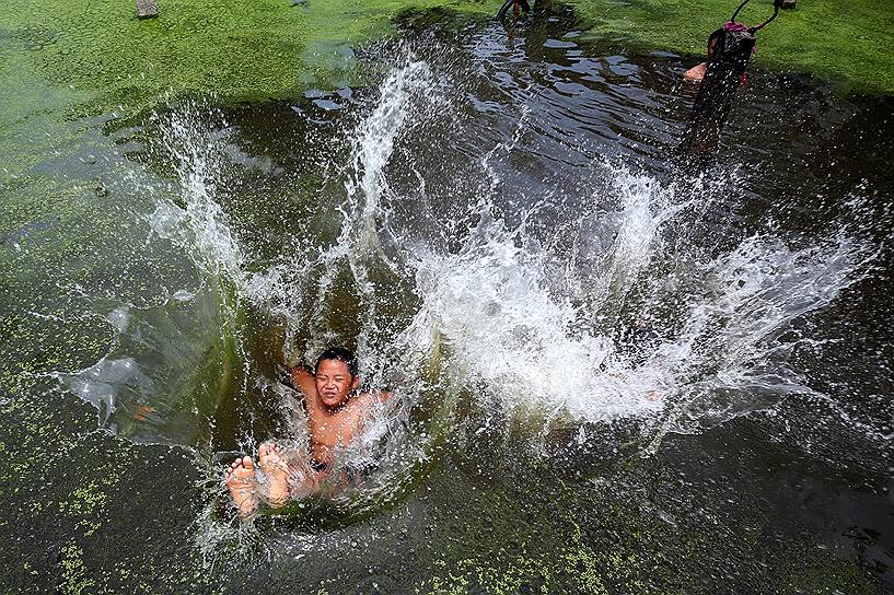 Ханой, Вьетнам. Мальчик прыгает в воду в жаркий день