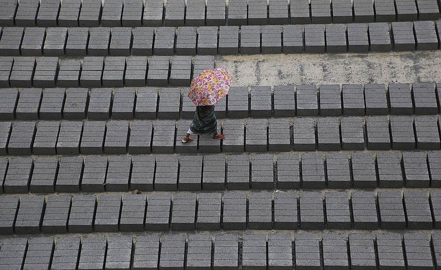 Бангалор, Индия. Женщина идет по цементным плитам во время дождя