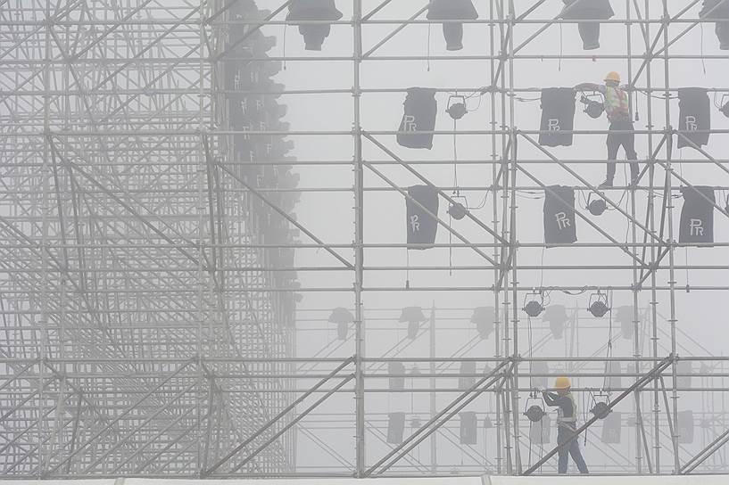 Далянь, Китай. Рабочие устанавливают освещение перед началом Всемирного экономического форума