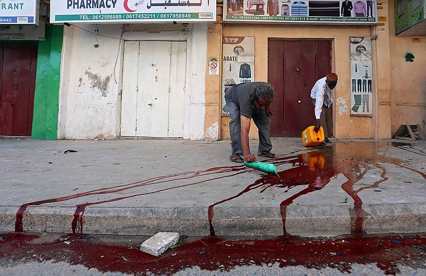 Могадишо, Сомали. Горожане убирают кровь после взрыва у полицейского участка 