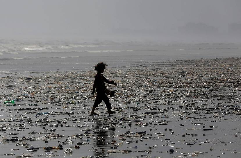 Карачи, Пакистан. Девочка идет по загрязненному пляжу