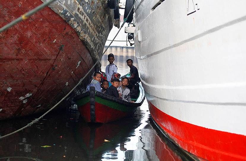 Джакарта, Индонезия. Местные жители плывут на лодке между кораблями на празднование окончания священного месяца рамадан 