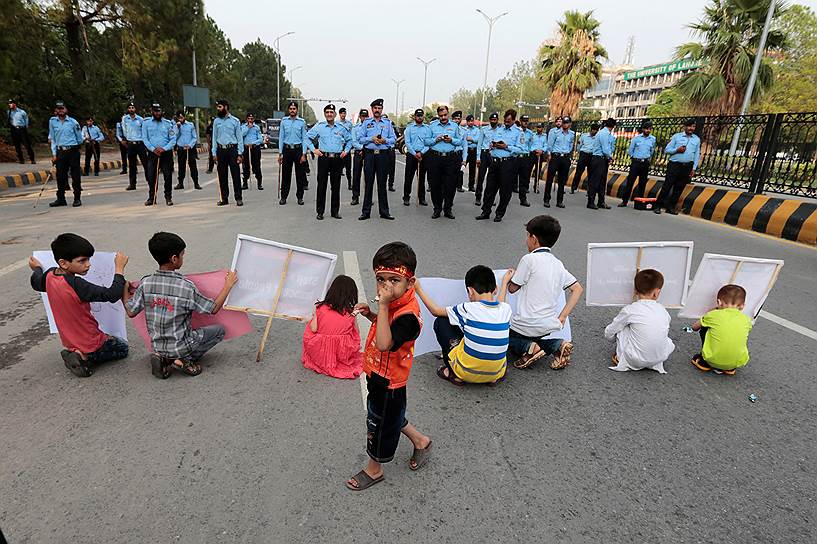 Исламабад, Пакистан. Дети с плакатами перед полицейскими во время демонстрации после терактов в городе Парачинар. Жертвами двух взрывов на городском рынке 24 июня стали 55 человек 