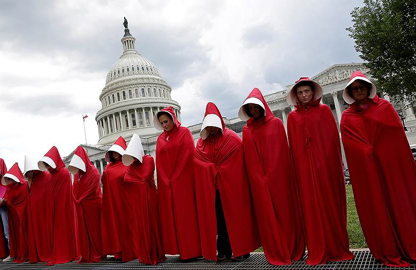 Вашингтон, США. Женщины, одетые в костюмы героини романа «Рассказы служанки», во время демонстрации против сокращения социальных выплат у стен Белого дома