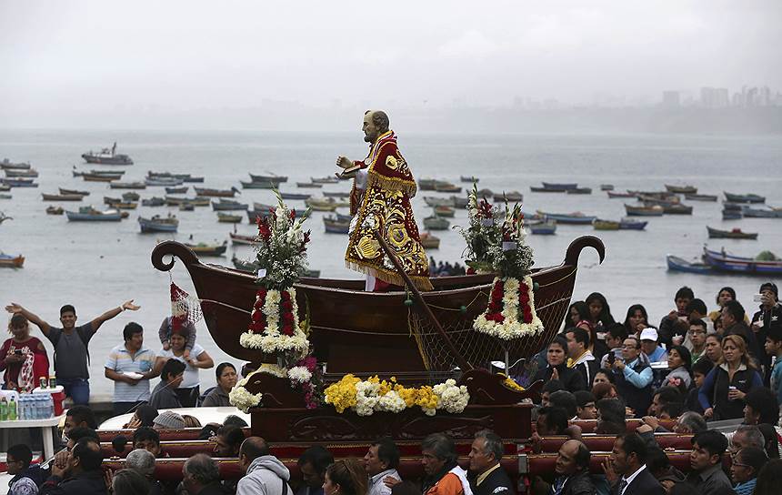Лима, Перу. Рыбаки несут статую святого Петра, который считается покровителем рыболовов, во время религиозного праздника