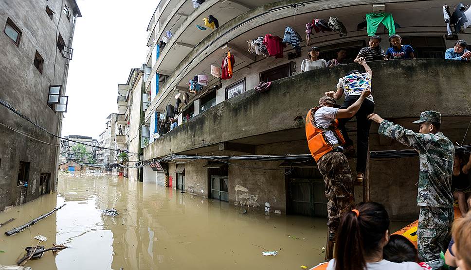 Гуйлинь, Китай. Спасатели на лодках помогают людям, оказавшимся в зоне затопления