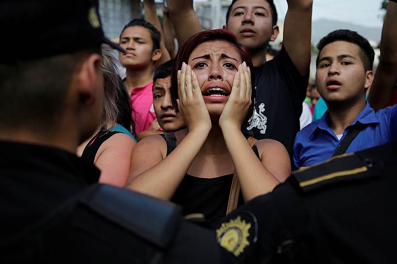 Лас-Гавиотас, Гватемала. Родственники демонстрантов наблюдают за тем, как полицейские берут протестующих в «кольцо»