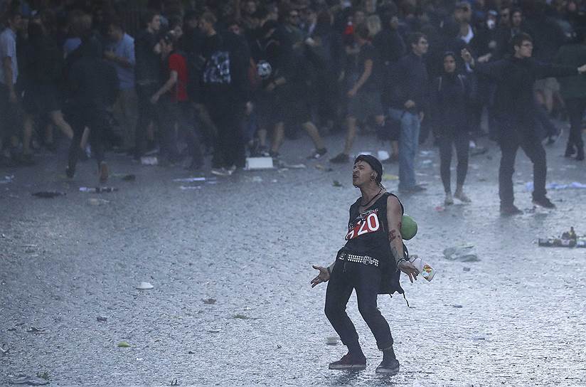 Противник G20 выбежал из толпы к полицейским машинам с водометами 