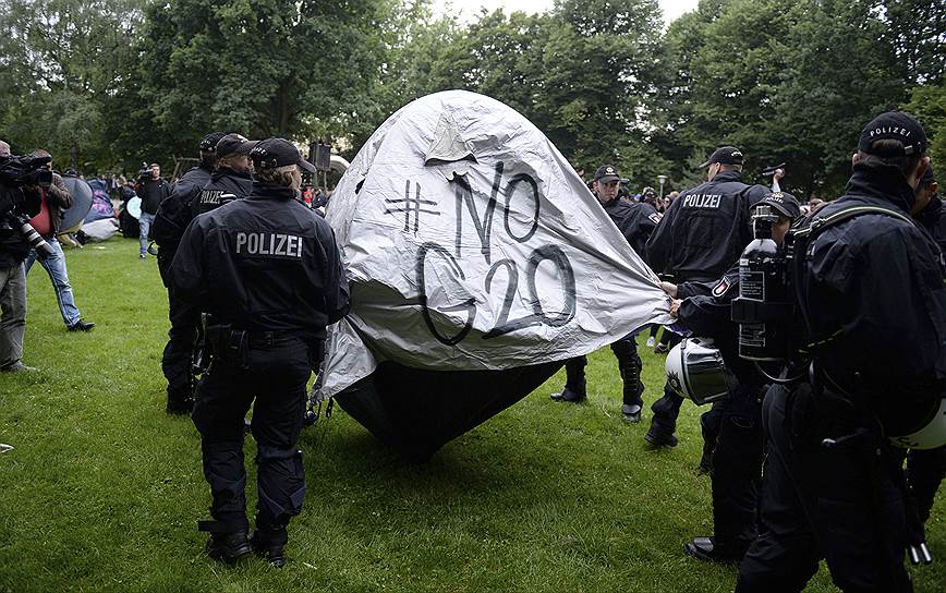 Полицейские убирают палатку, которую установили протестующие в городском парке