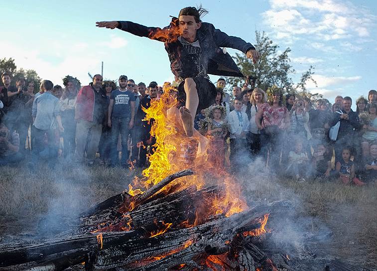 Киев, Украины. Мужчина прыгает через костер во время празднования традиционного праздника Ивана Купалы