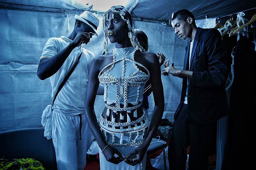 Дакар, Сенегал. Малийский дизайнер Омар Дико одевает модель во время Недели моды 