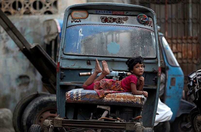 Карачи, Пакистан. Девочка лежит на рикше, припаркованной на улице