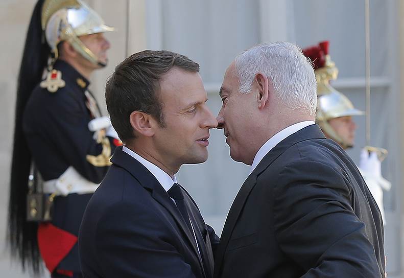 Президент Франции Эмманюэль Макрон приветствует премьер-министра Израиля Биньямина Нетаньяху в Елисейском дворце