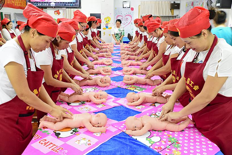 Провинция Хайнань, Китай. Люди на бесплатном курсе по уходу за младенцами, организованном местным профосюзом