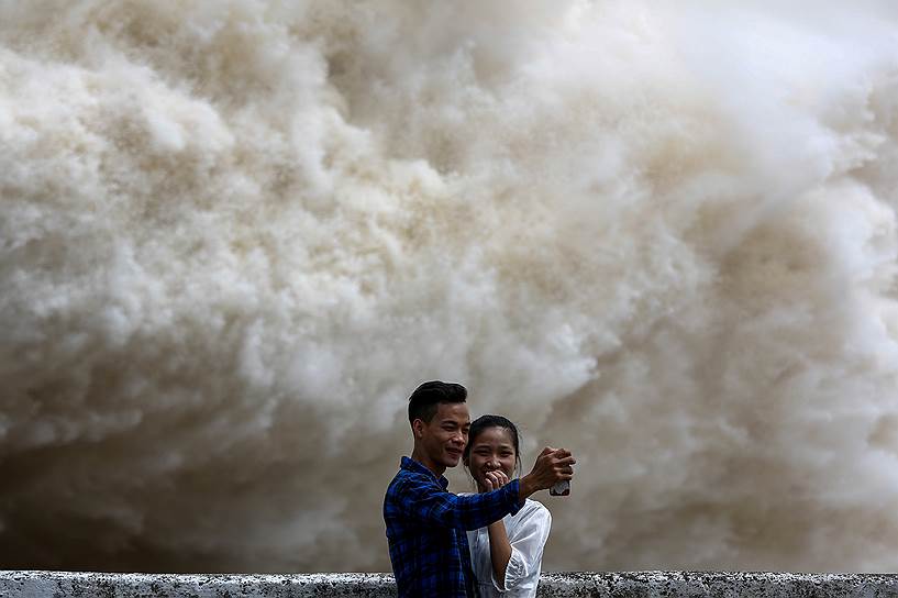 Провинция Хоа Бинь, Вьетнам. Пара делает селфи на фоне водяного шквала — местная гидроэлектростанция сбрасывает воду, накопившуюся после сильного ливня, вызванного тайфуном 