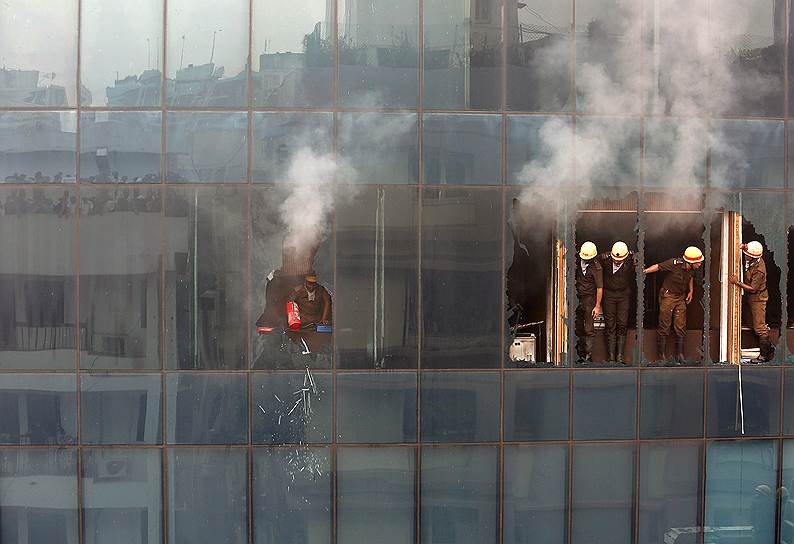 Калькутта, Индия. Пожарные разбивают окно в офисном здания в ходе борьбы с огнем