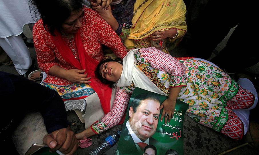 Лахора, Пакистан. Сторонница премьер-министра Пакистана Наваза Шарифа упала в обморок после решения Верховного суда о его отстранении от власти 