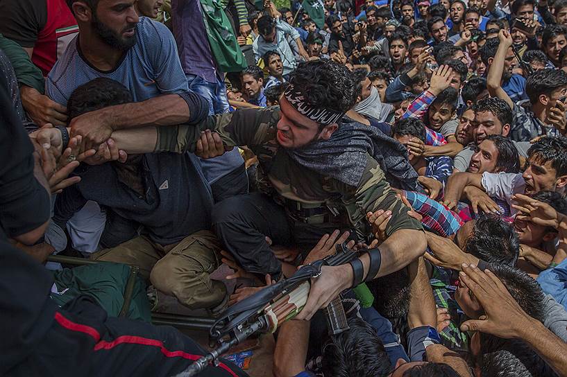 Шринагар, Индия. Жители деревни помогают кашмирскому солдату взобраться на сцену во время похорон повстанца Сухала Ахмеда, который был убит в засаде правительственными войсками Индии в Тантрайпоре