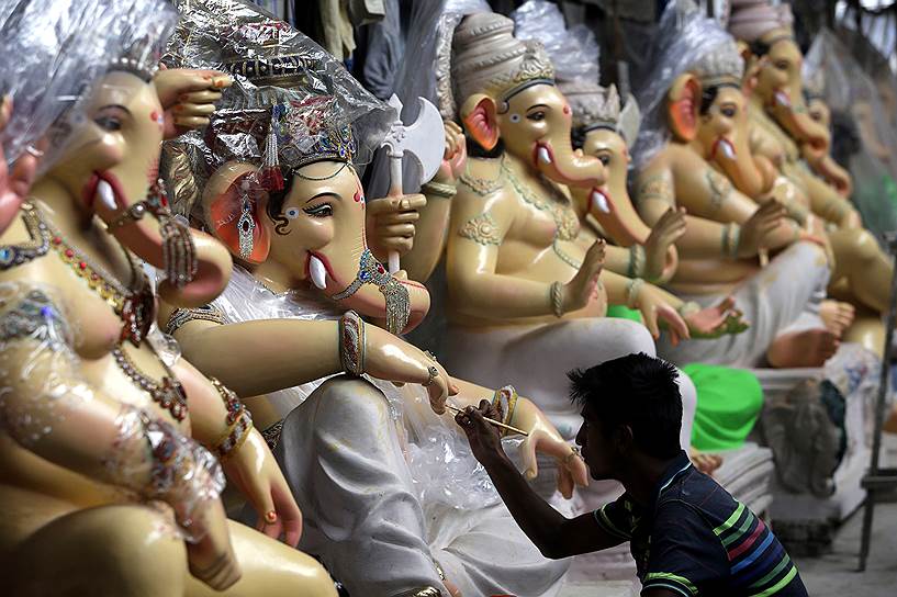 Мумбай, Индия. Художник раскрашивает идола с головой слона, символизирующего бога Ганеша, в преддверии фестиваля Ганеша-чатуртхи