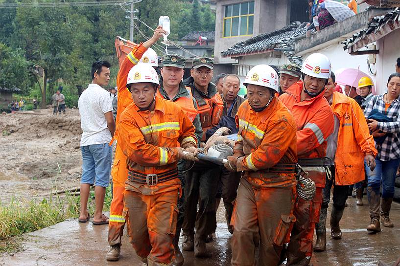 Гэнди, Китай. Спасатели несут пострадавшего во время землетрясения. Из-за оползня селя погибли четыре человека, более 30 пострадали