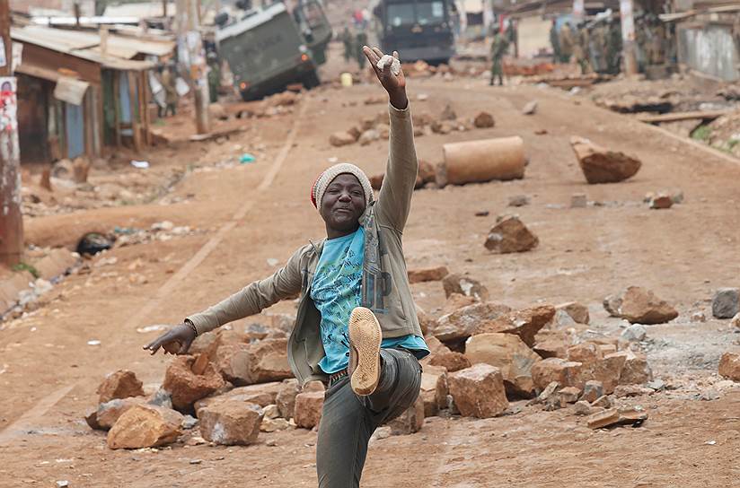 Найроби, Кения. Сторонник лидера оппозиции Раила Одинго позирует на фоне баррикад в трущобах Кавангваре