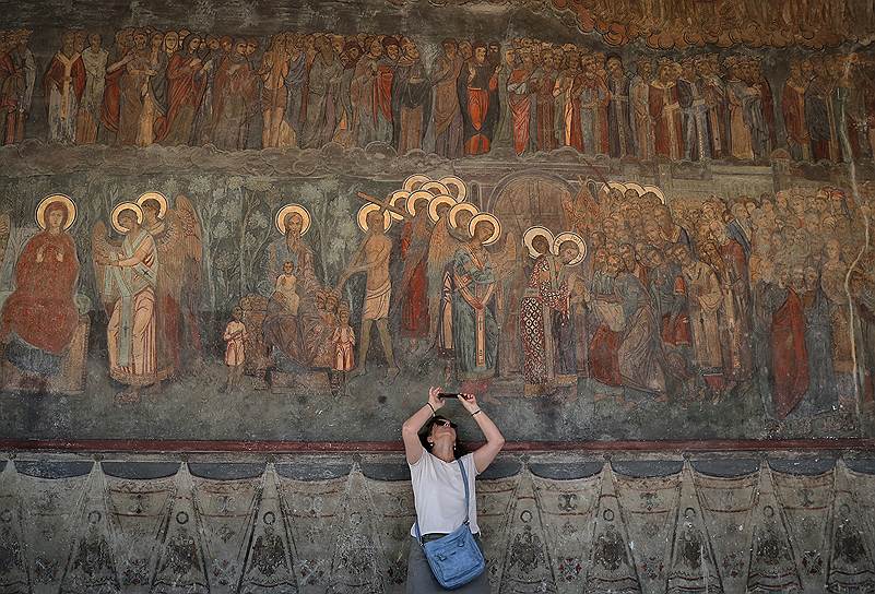 Бухарест, Румыния. Турист фотографирует расписанную стену Патриаршего собора