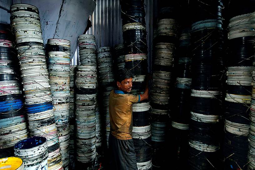 Мумбаи, Индия. Рабочий несет ведра с краской