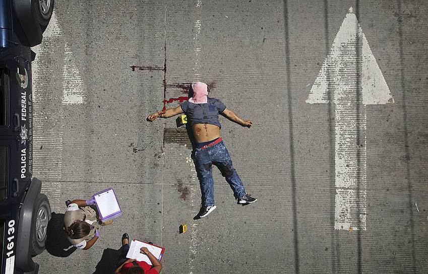 Акапулько, Мексика. Следователи отмечают расположение тела мужчины, который был застрелен днем на центральной улице города