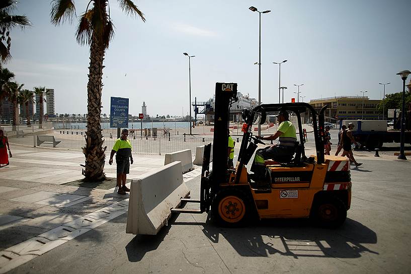 Рабочие устанавливают каменный забор в Малаге, Испания