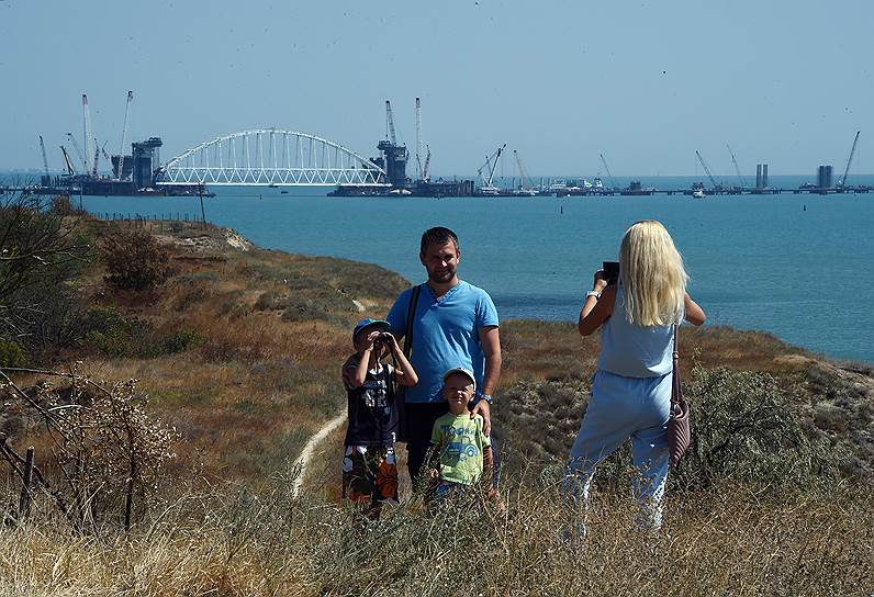 Керченский пролив. Туристы фотографируются на фоне железнодорожной арки моста в Крым 