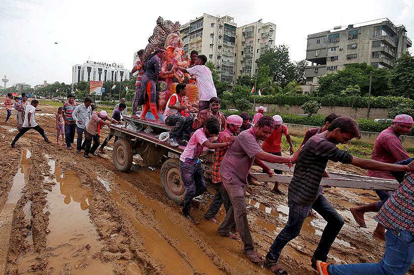 Ахмедабад, Индия. Люди перевозят статую бога Ганеши во время фестиваля в его честь