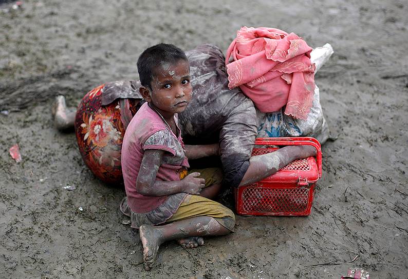 Текнаф, Бангладеш. Маленькая беженка-рохинджа сидит рядом с матерью, отдыхающей после пересечения границы между Бангладешем и Мьянмой 