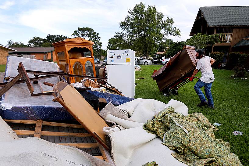 Порт-Артур, США. Мужчина выносит из дома пострадавшие от урагана «Харви» вещи