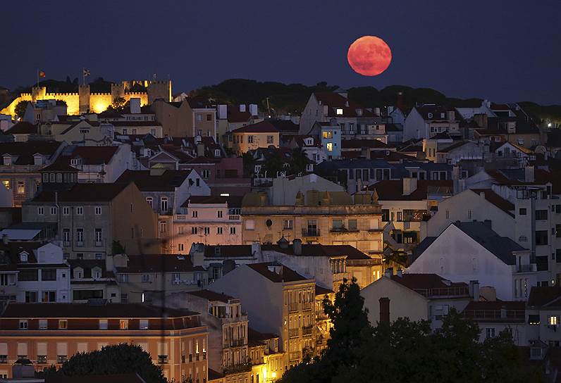 Лиссабон, Португалия. Полная луна позади замка Святого Георгия