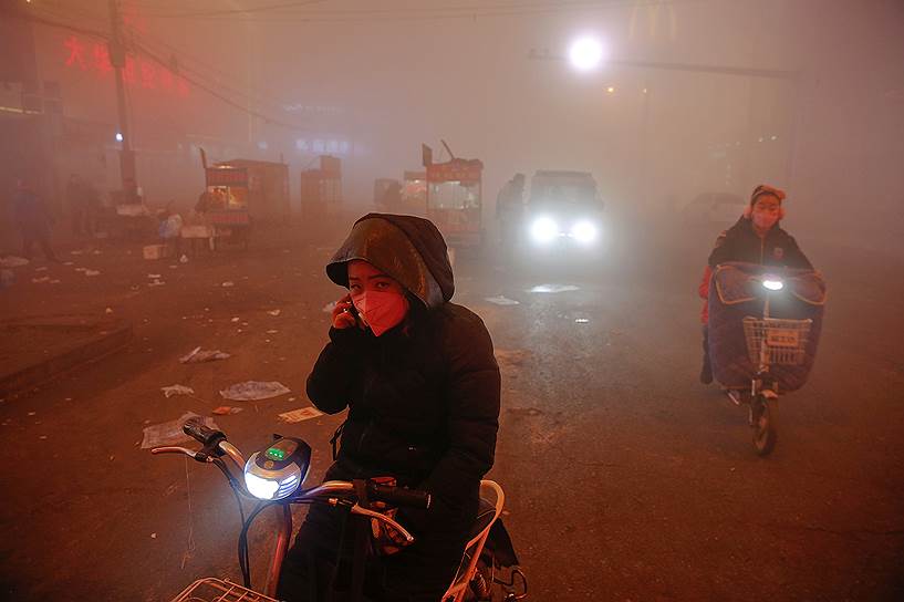 Шенфан, провинция Хэбэй, Китай. Люди пробираются сквозь смог после объявления &quot;красного&quot; уровня загрязнения воздуха